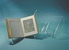 Acrylic stands in front of a light blue background, an illuminated manuscript displayed on one